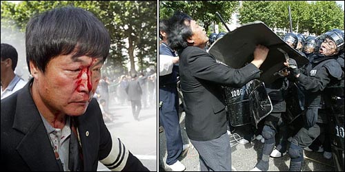 세계무역기구(WTO) 각료회의가 열리는 멕시코 칸쿤에서 자결한 고 이경해씨의 세계농민장이 열린 9월 20일 오후 서울 송파구 올림픽공원 부근에서 한 경찰이 시위자의 얼굴을 방패로 공격하고 있다. 부상자의 이마에서 피가 흘러내리고 있다. 